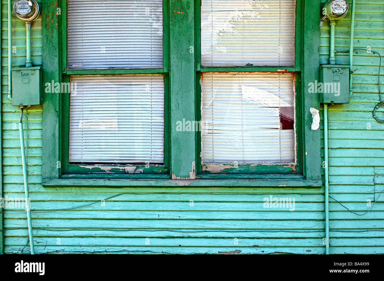 Out dated windows with electrical and communication wires randomly attached Stock Photo