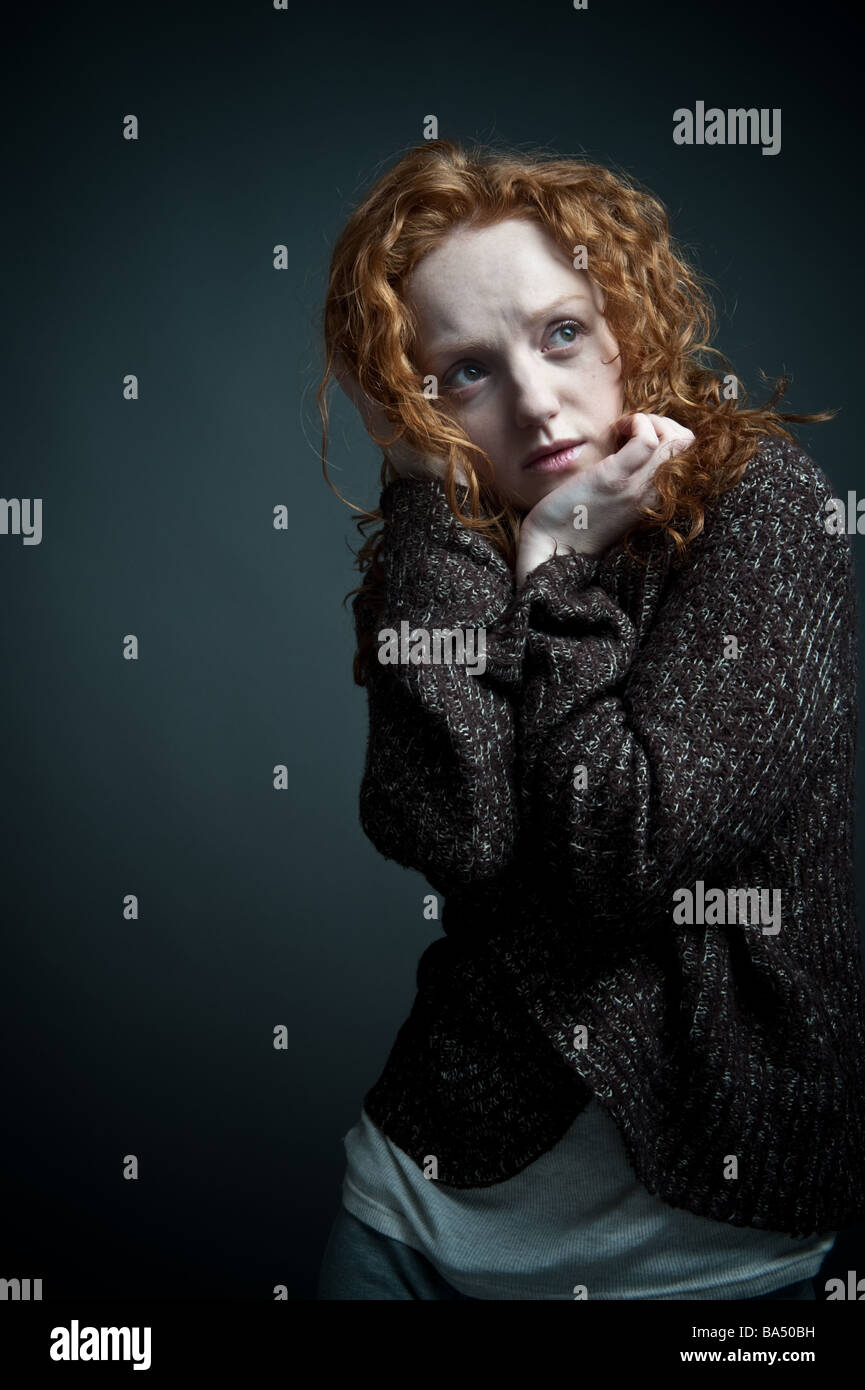 sad vulnerable red haired woman girl alone withdrawn introspective Stock Photo