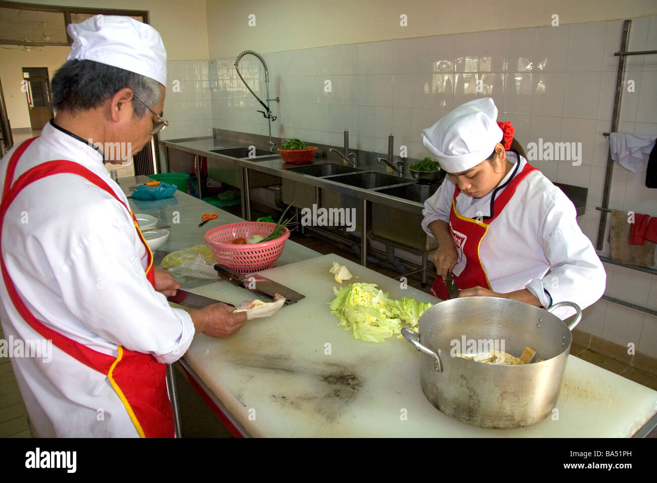 Chefs prepare food at a trade school in Dong Ha Vietnam Stock Photo