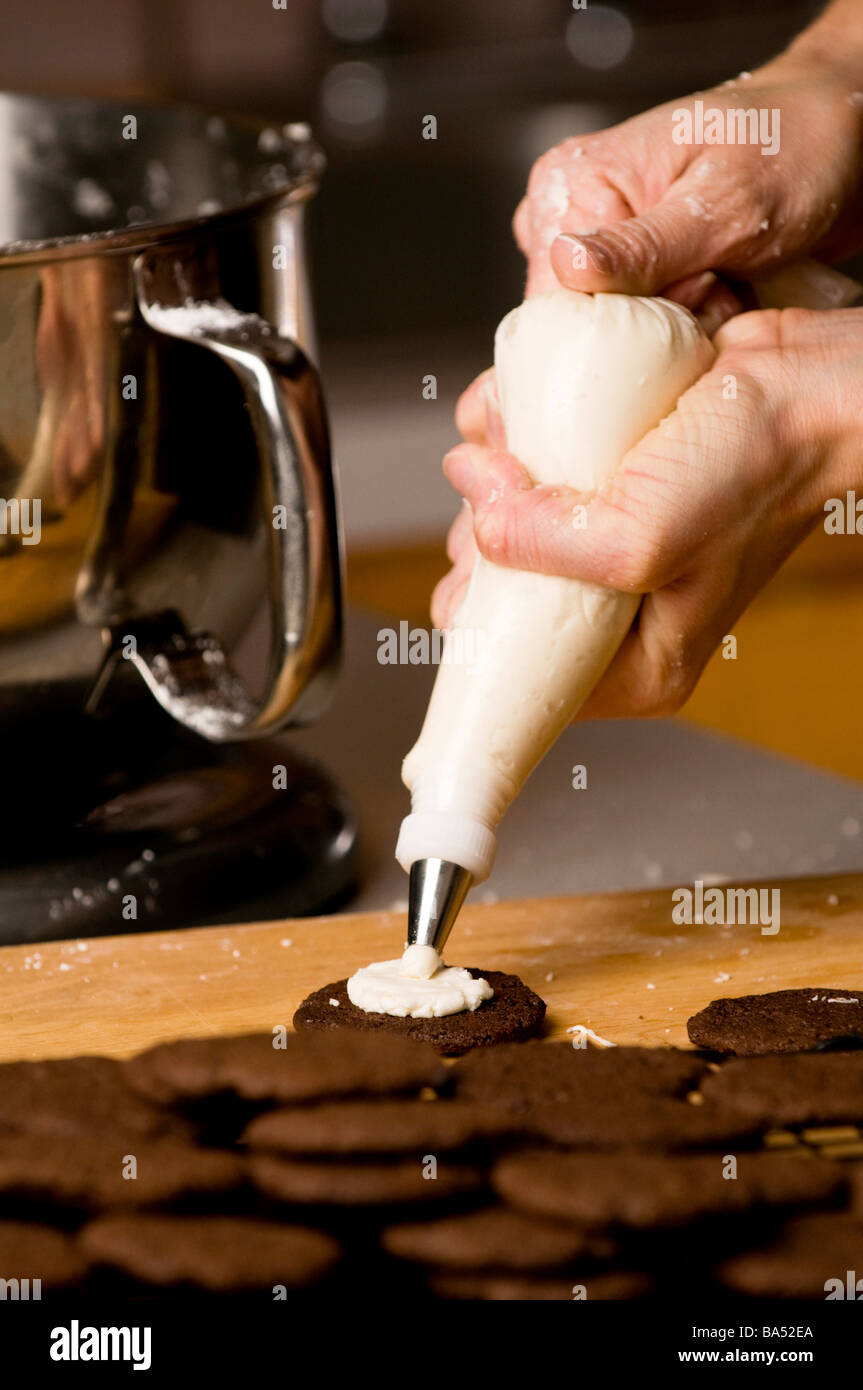 baker adding icing to cookies Stock Photo
