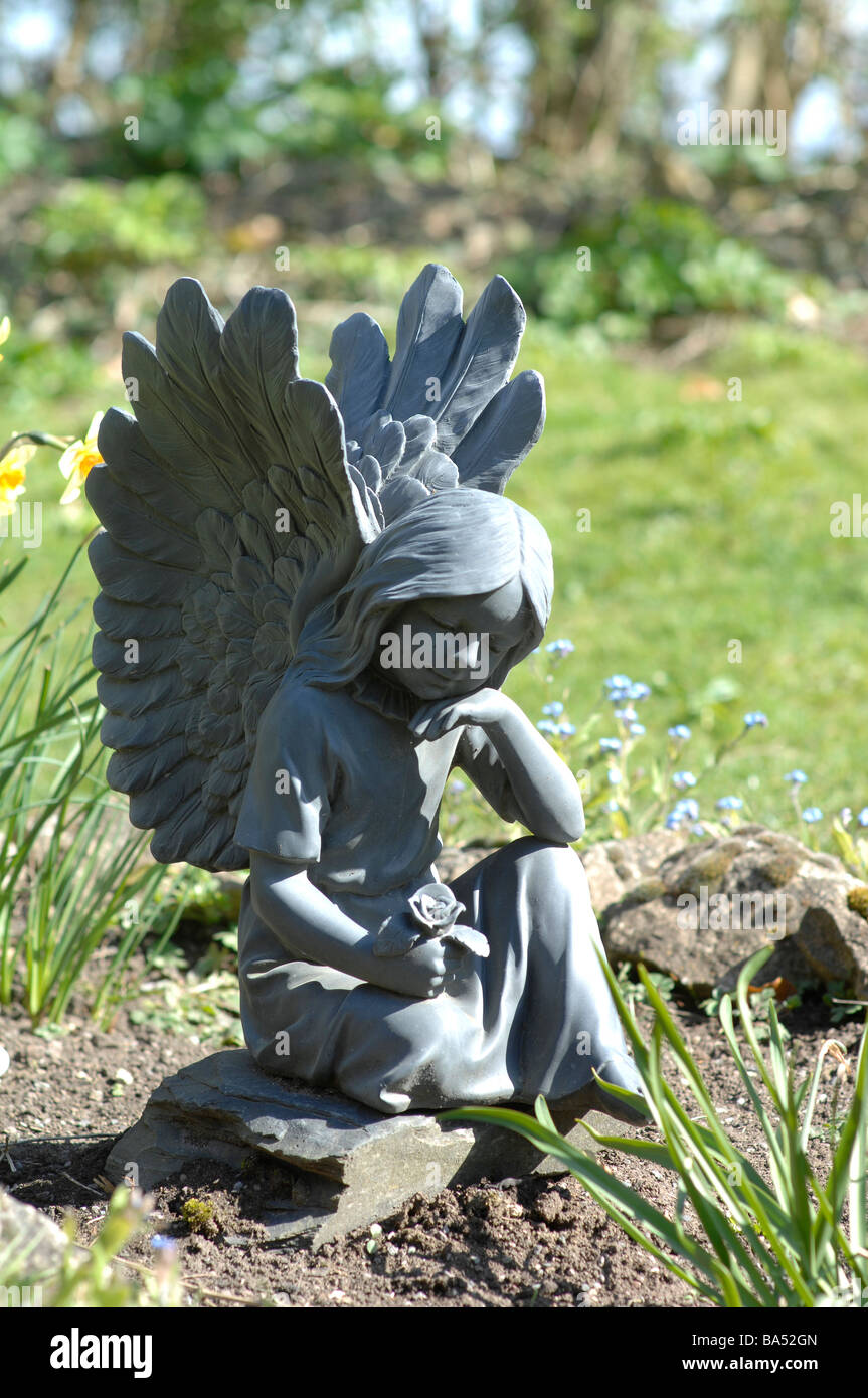 Angel with Forget-Me-Not in graveyard Stock Photo
