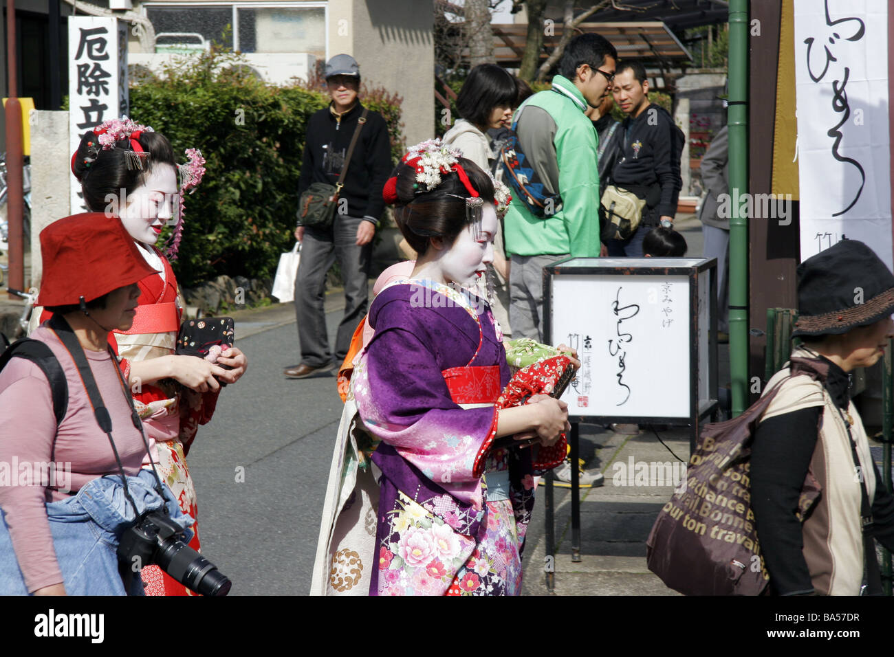 Geisha walking amoungst tourists in the streets of Arashiyama Kyoto Japan Stock Photo