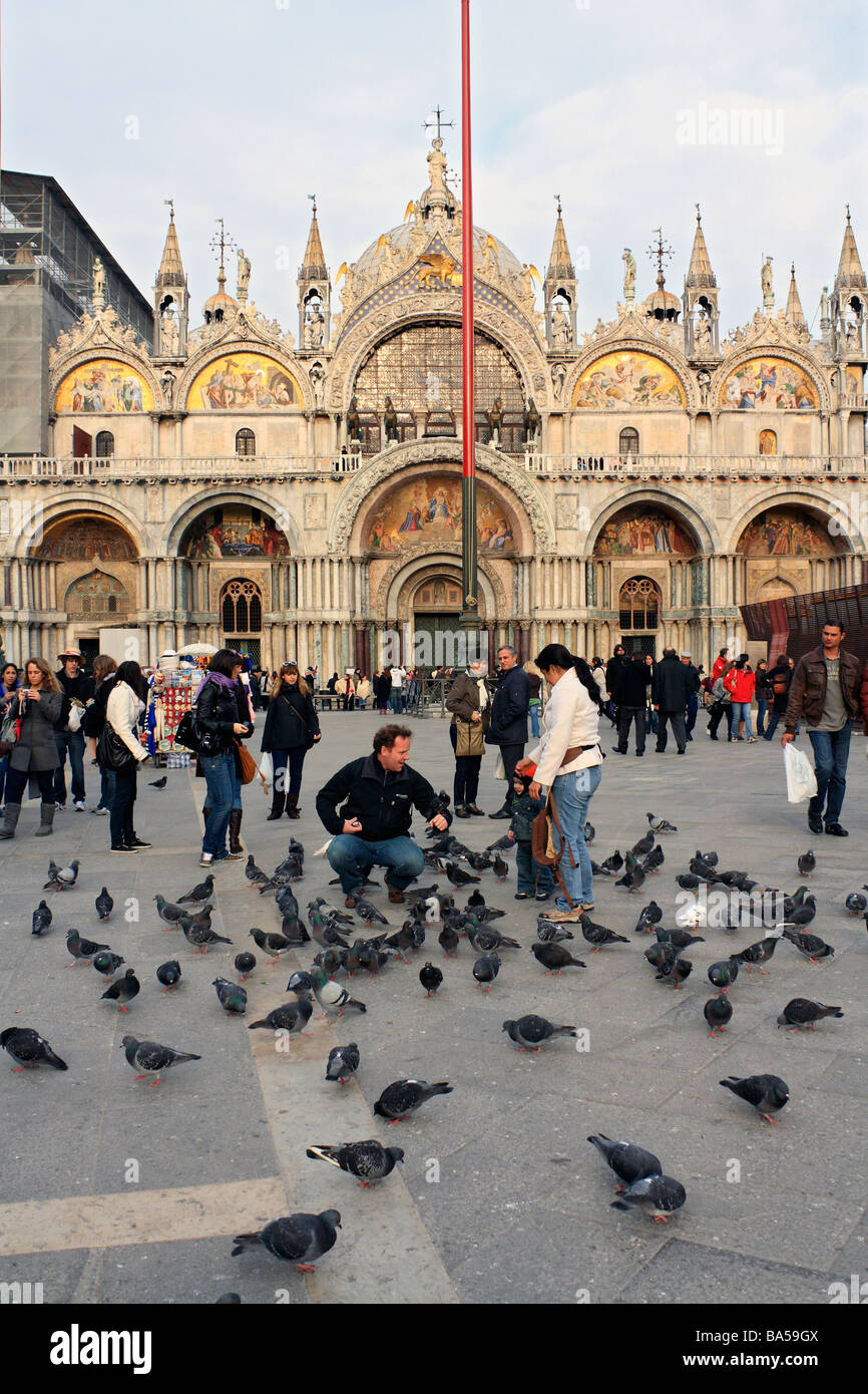 People feeding the pigeons in front of the Basilica in Saint Mark's Square (Piazza San Marco