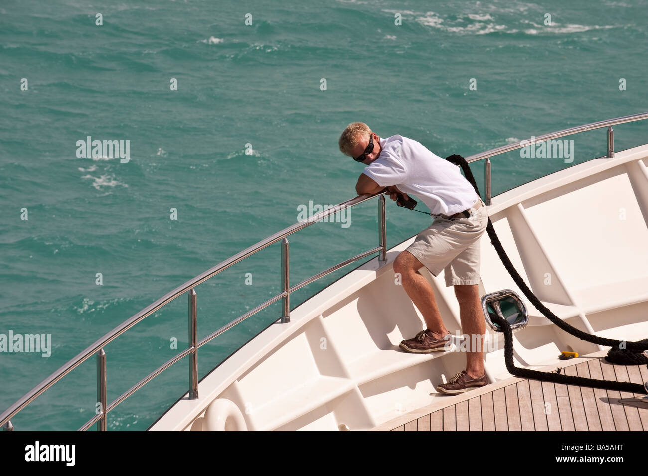 Deckhand on the foredeck standing by the dropping of the anchor Stock Photo