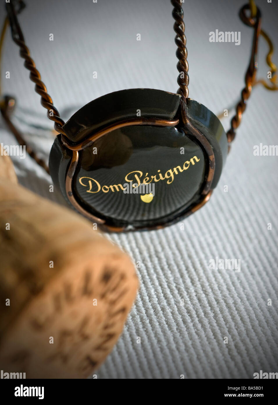 Dom Perignon champagne cork with wire retaining frame and cap on dining tablecloth Stock Photo