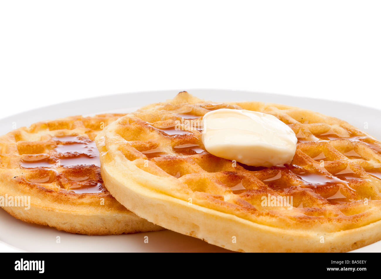 A horizontal closeup of two frozen breakfast waffles with a pat of