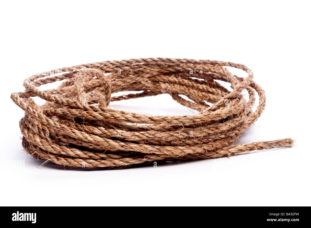 A horizontal view of a coil of rope on white Stock Photo