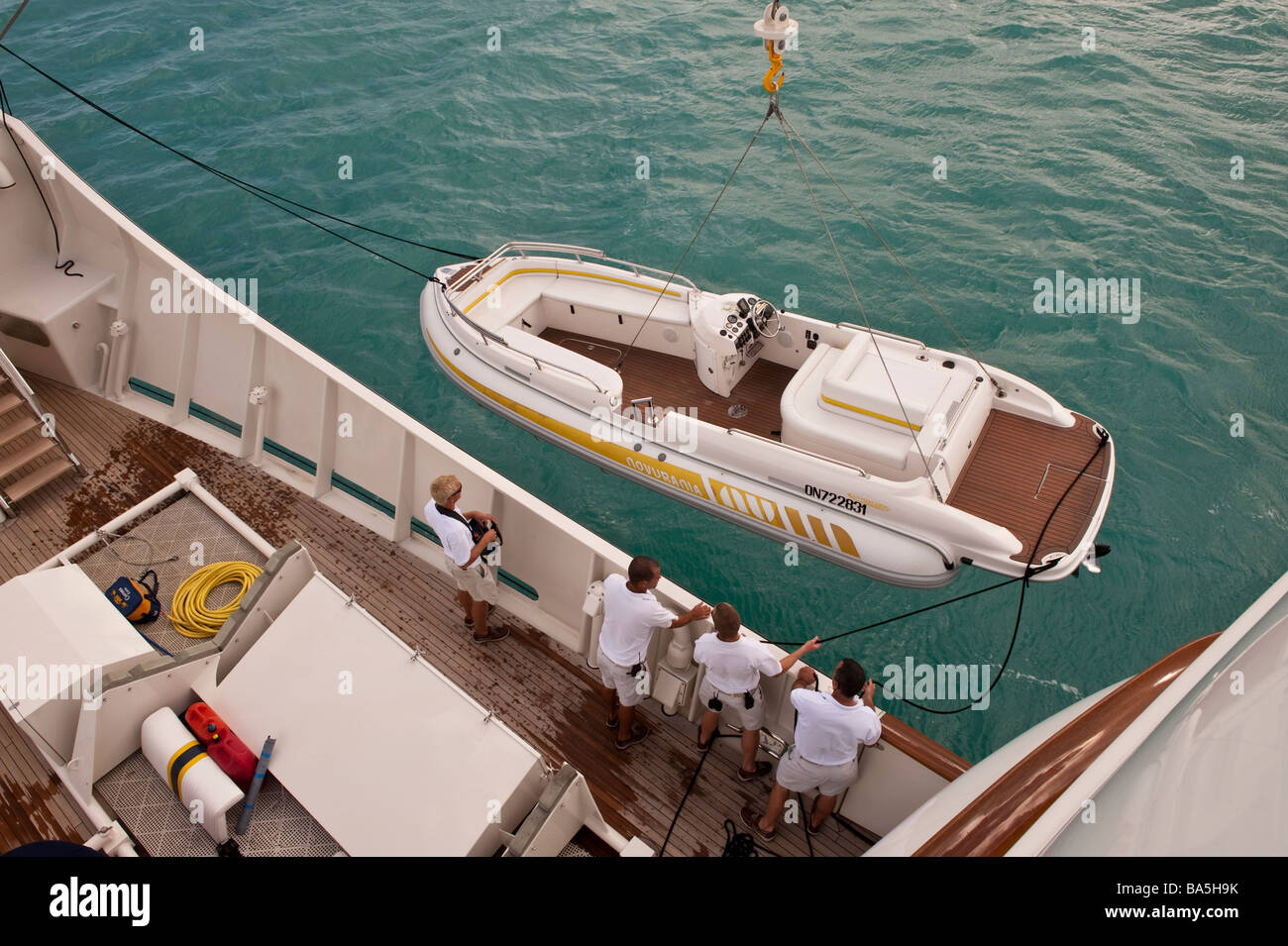 Crew craning the tender on the foredeck of superyacht 'Big Aron' into the water Stock Photo