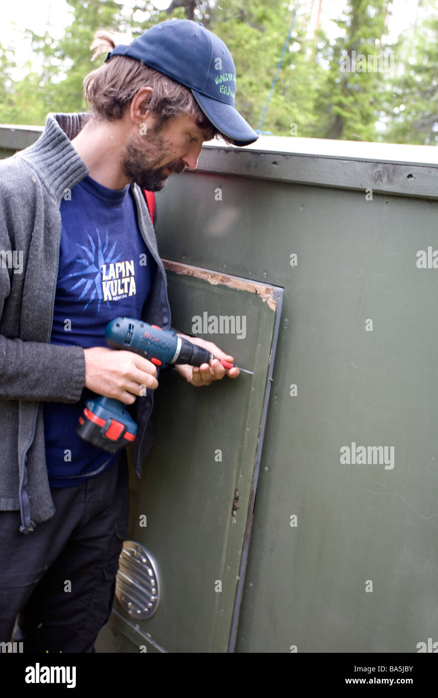 Guide securing wooden bear hide in finland Stock Photo Alamy