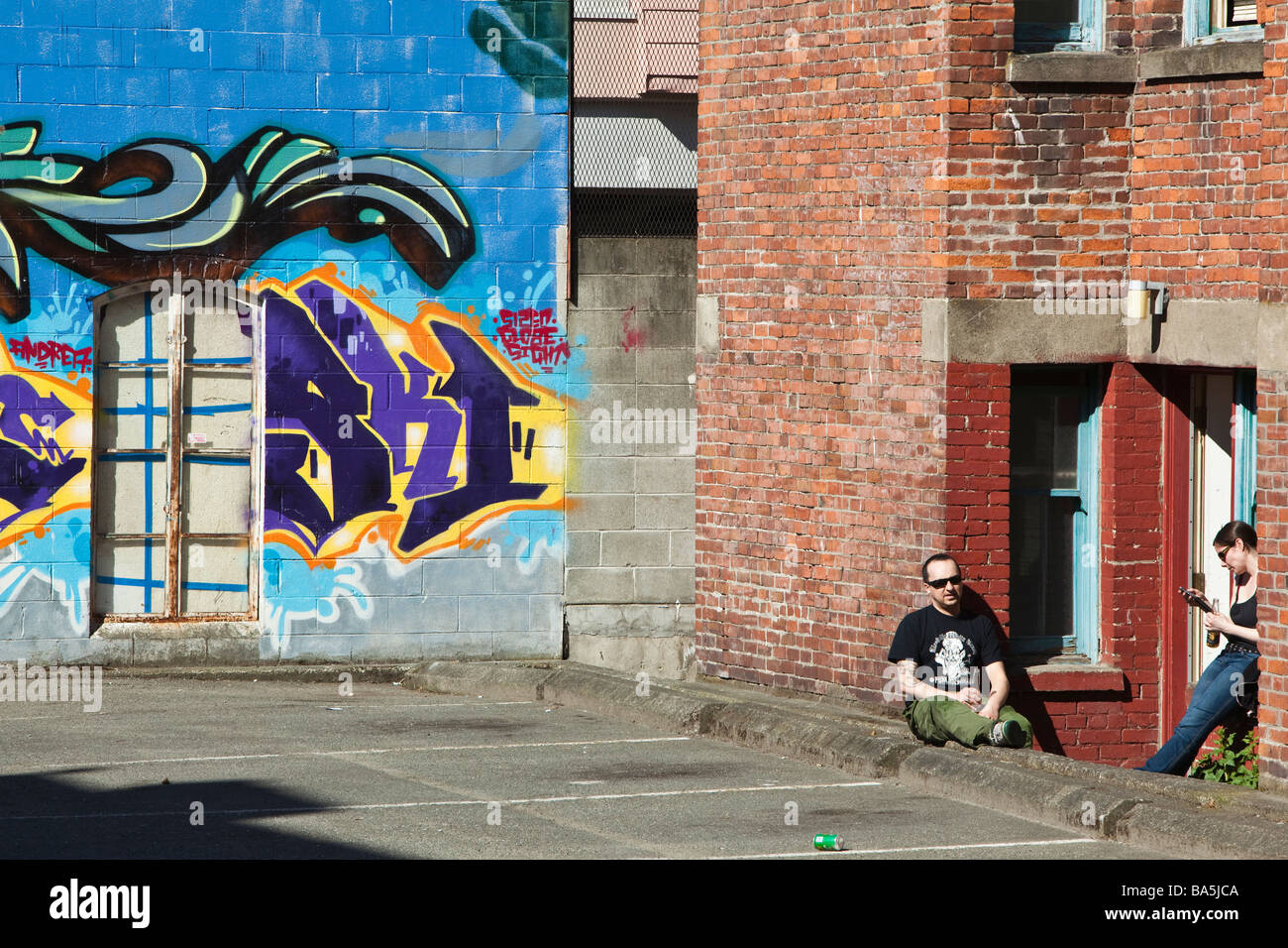 People in front of a wall with graffiti in downtown Victoria BC Canada