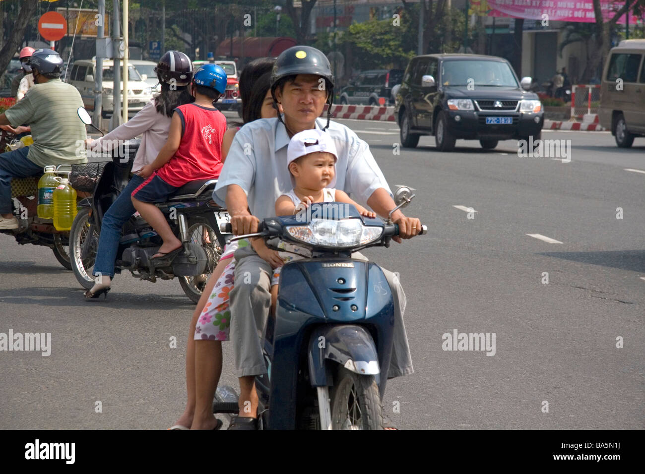 Vietnamese family riding motorbikes in Ho Chi Minh City Vietnam Stock Photo