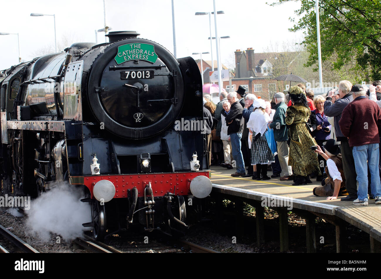 Oliver Cromwell steam engine pulling The Cathedrals Express train into Petersfield railway station crowded platform Stock Photo
