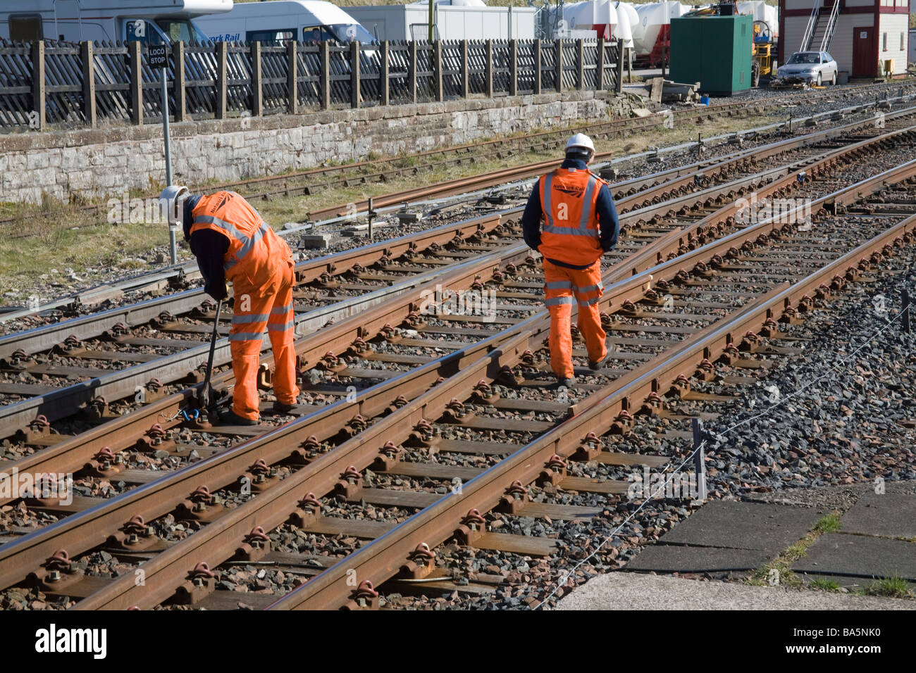 Northern England UK March Two Network Rail employees safety checking rail lines and tightening nuts as necessary Stock Photo