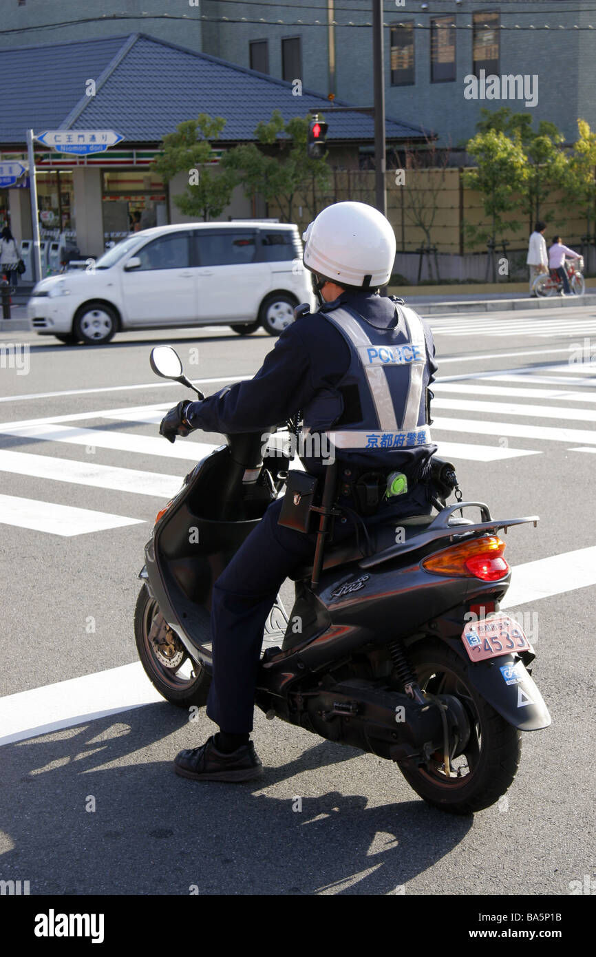 Japanese police officer riding a moped in Kyoto Japan Stock Photo
