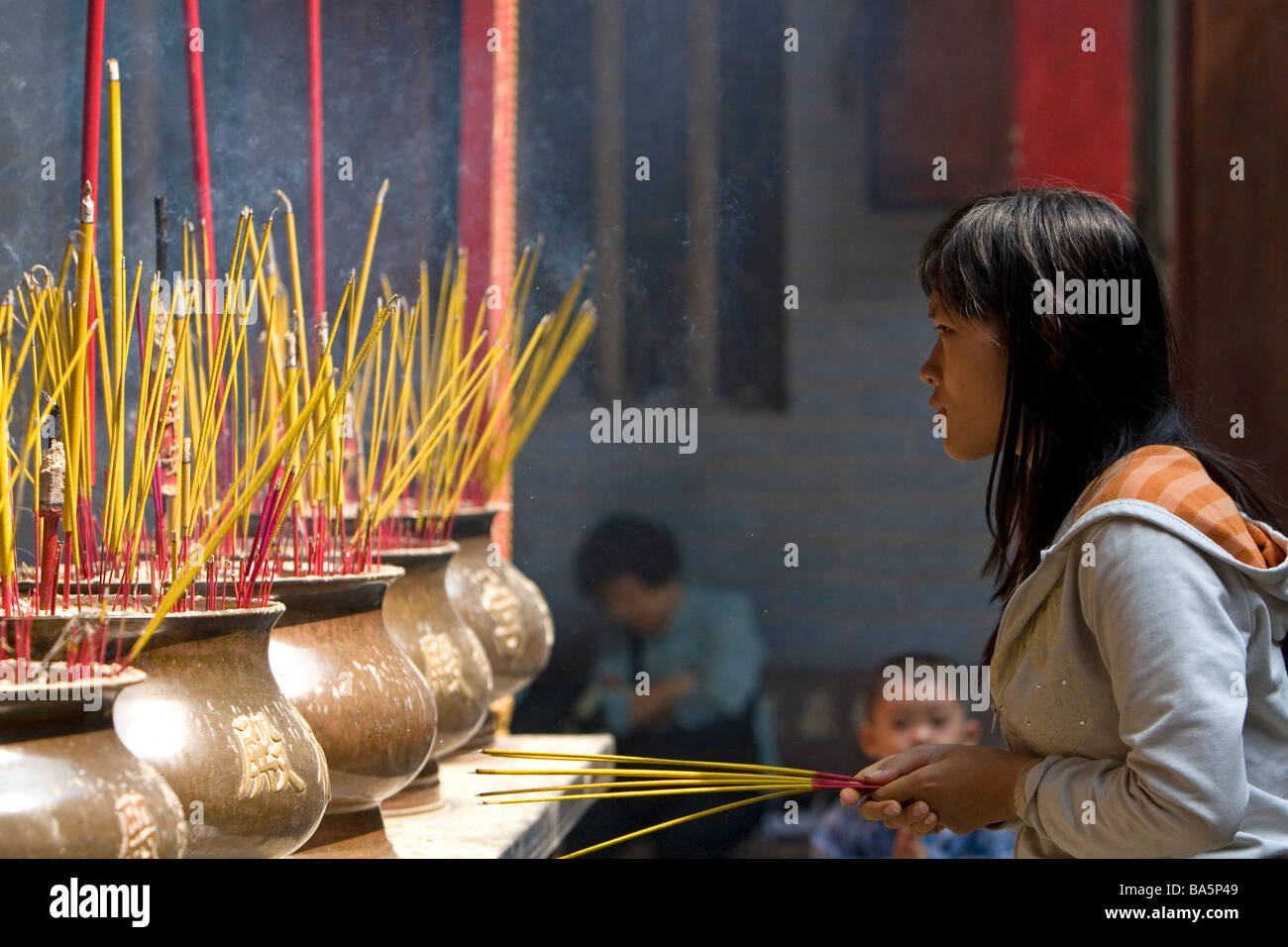 Vietnamese woman burning incense at the Quan Am Pagoda a Chinese temple