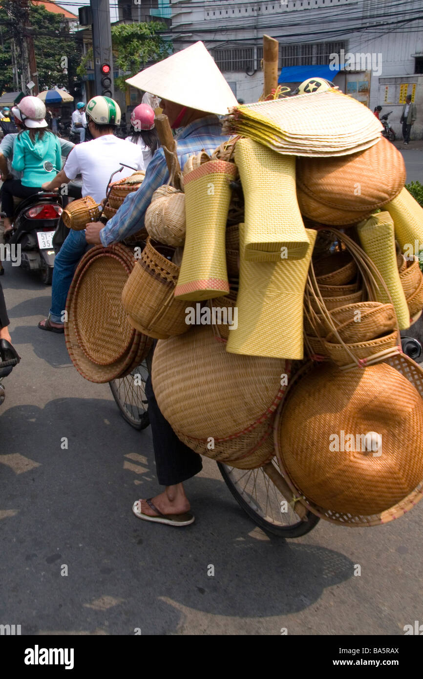 Vietnamese man riding a bicycle with many baskets in Ho Chi Minh City Vietnam Stock Photo