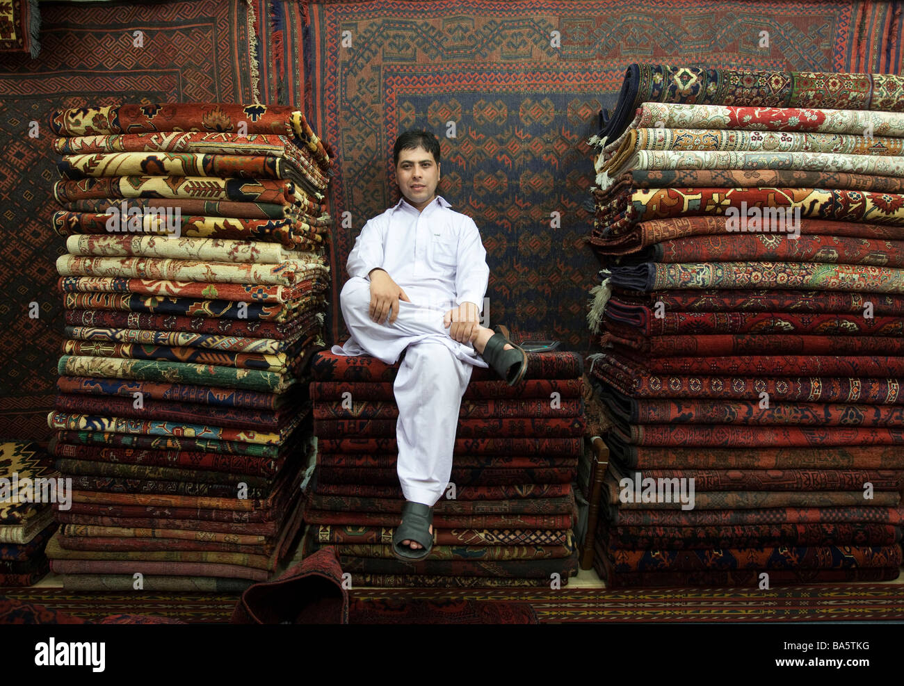 A carpet seller in Islamabad Pakistan sits among his stock that are