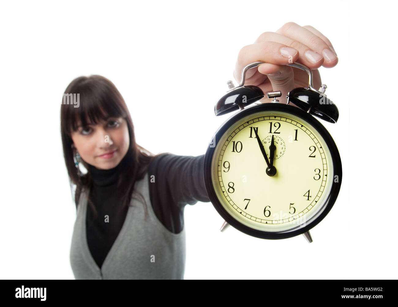 Pretty girl showing alarm clock only clock is in focus Stock Photo Alamy