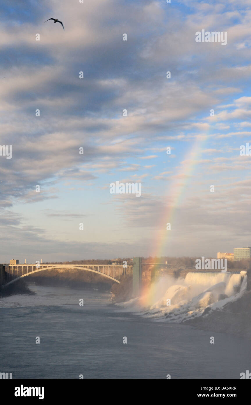 Rainbow and sun on the American Niagara Falls with the Rainbow bridge over the Niagara river with bird from the Canadian side Stock Photo