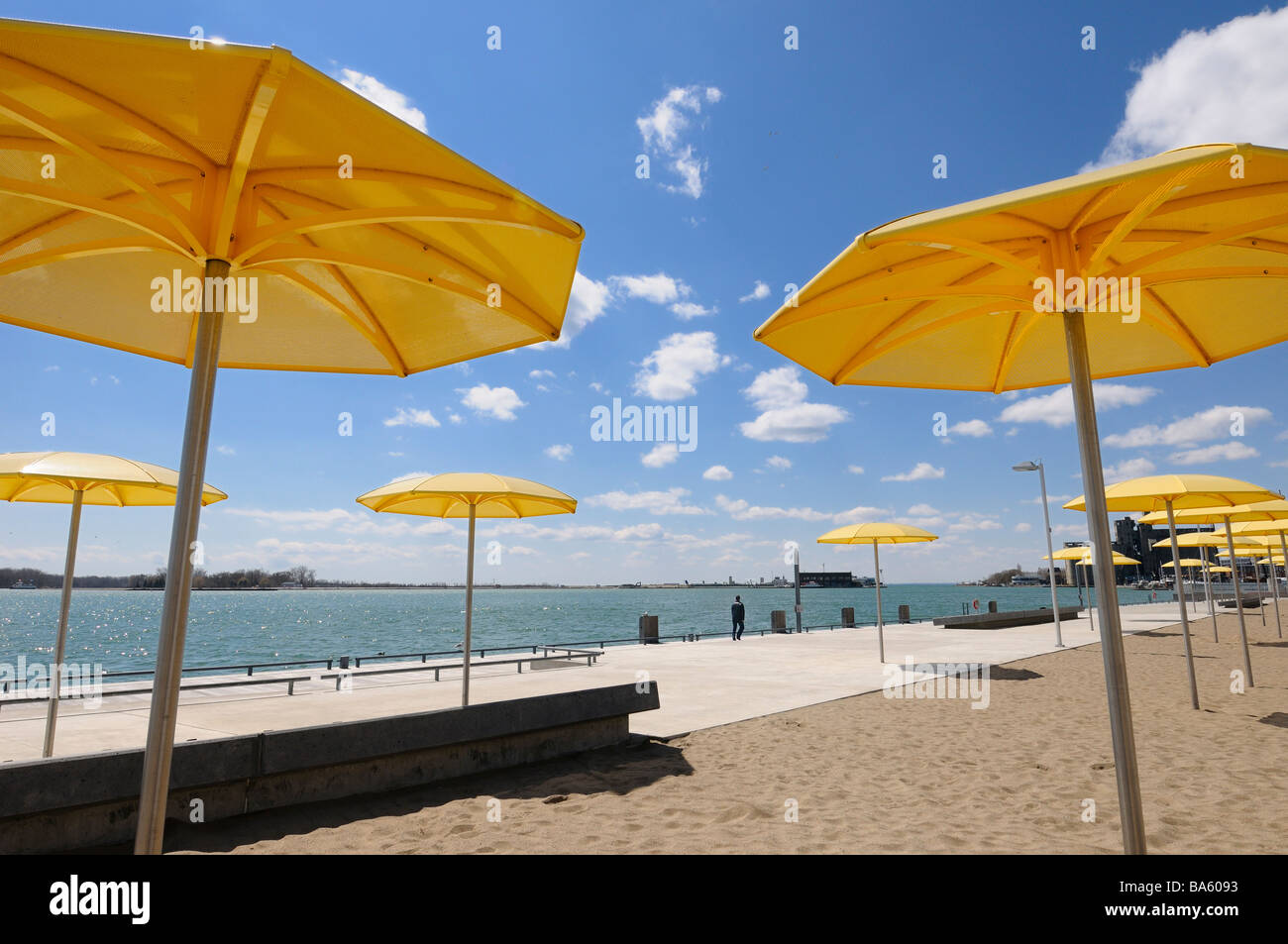 Yellow metal beach umbrellas at urban beach of HTO Park on Lake Ontario with Toronto Island airport Stock Photo