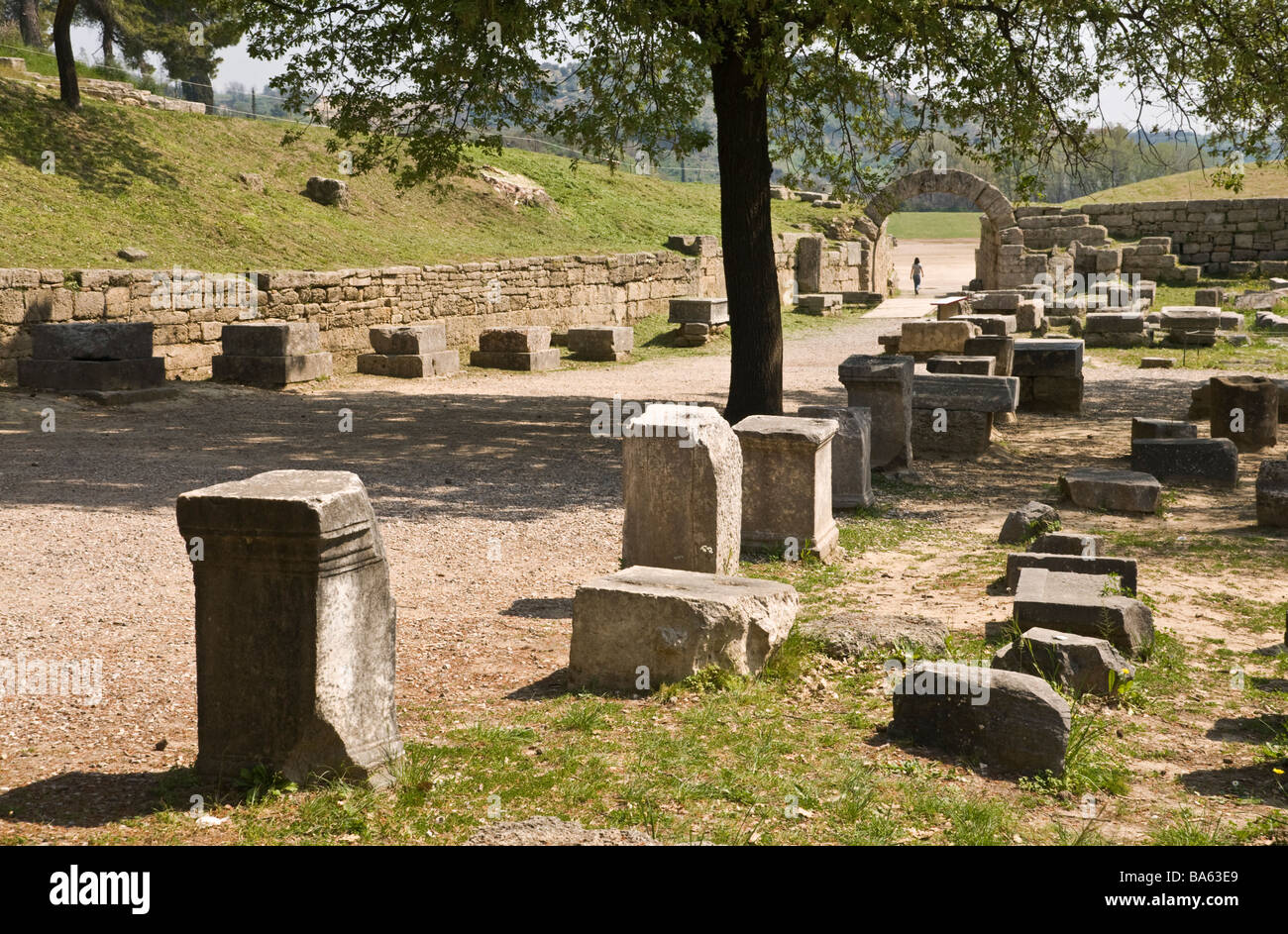 Ancient statue bases line the route to the stadium and its arched entrance way at ancient Olympia Peloponnese Greece Stock Photo