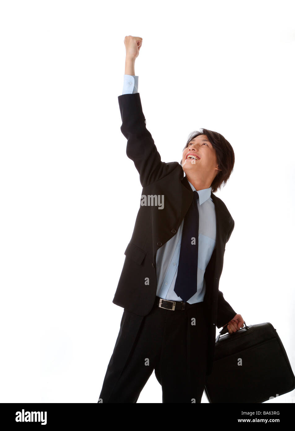 Businessman cheering with one fist raised laughing Stock Photo - Alamy