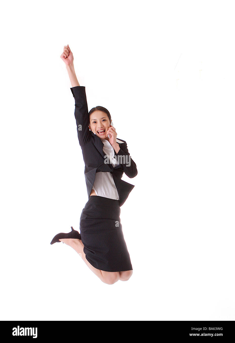 Businesswoman jumping in air smiling Stock Photo - Alamy