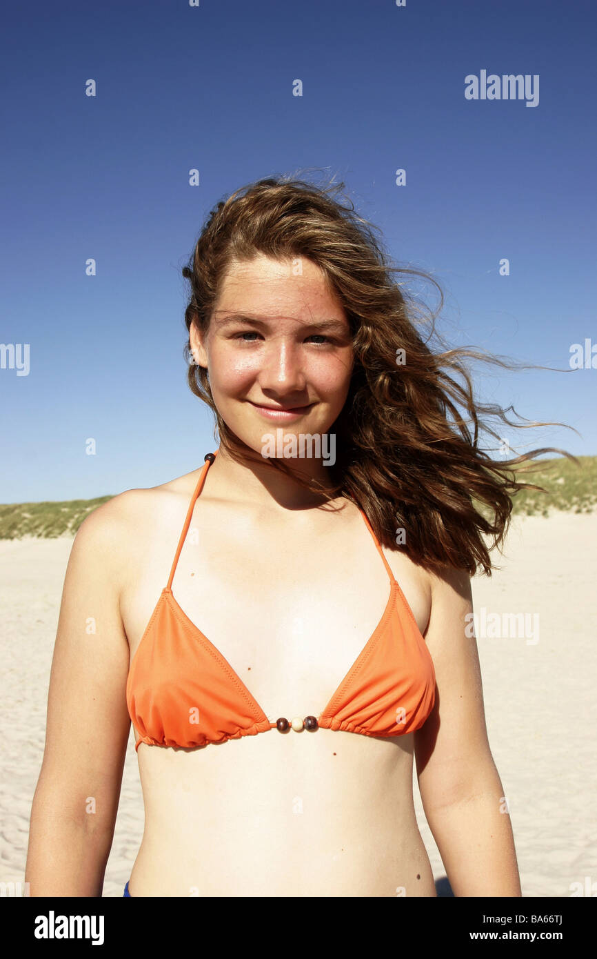 Beach girls bikini smiles stands semi-portrait series people teenagers  teenagers 13-16 years long-haired brunette hair wind Stock Photo - Alamy