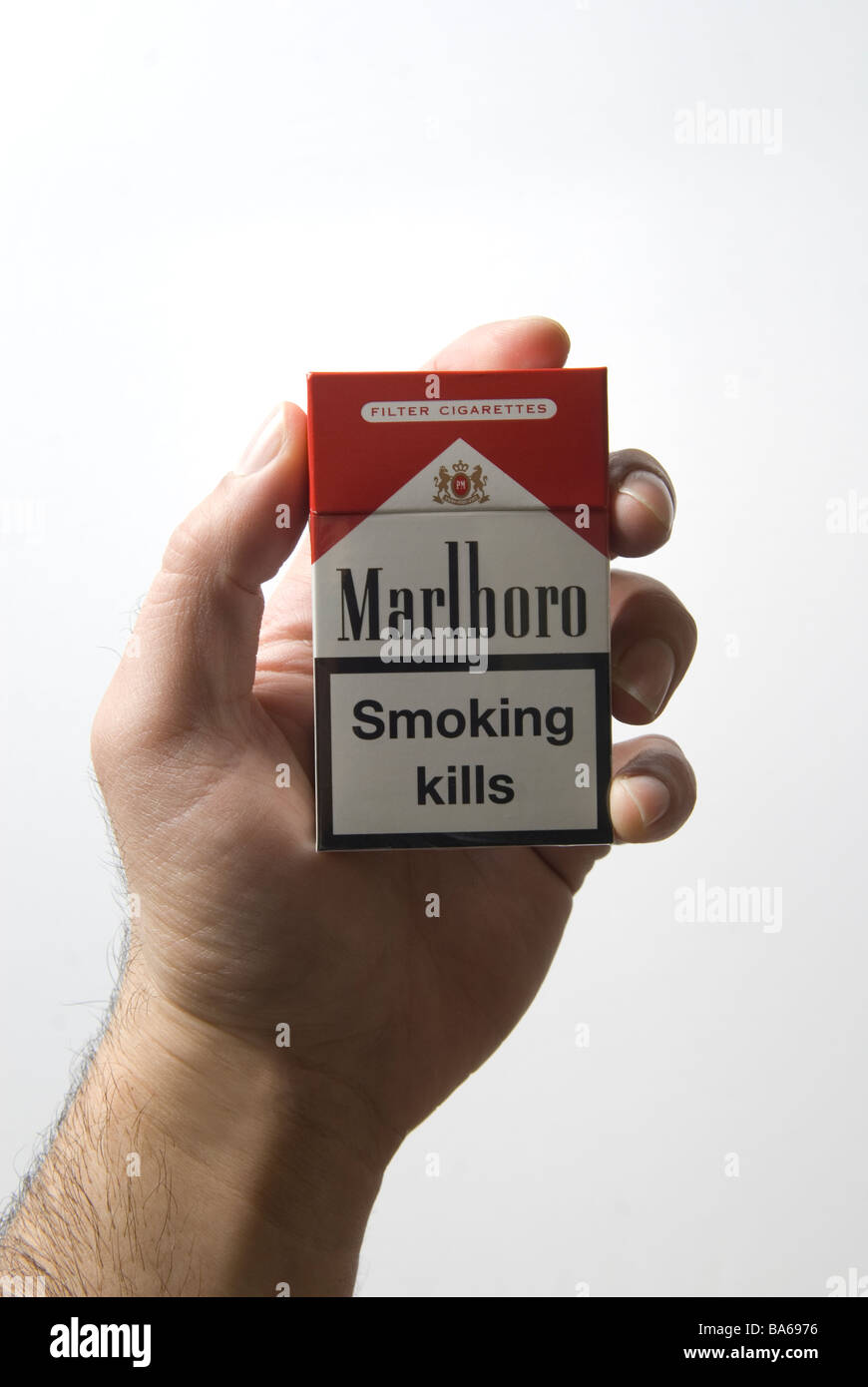 Man's hand holding a red Marlboro cigarettes packet with a smoking kills warning Stock Photo