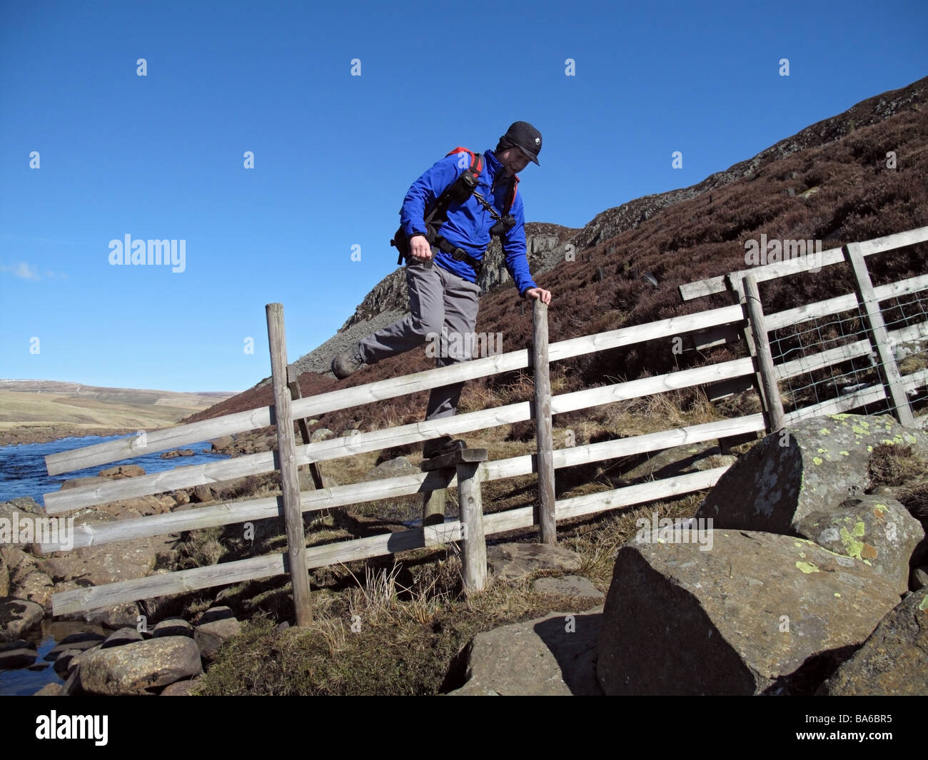 Hill Walker Crossing a Stile Next to the River Tees Below Cronkley Scar Upper Teesdale County Durham Stock Photo