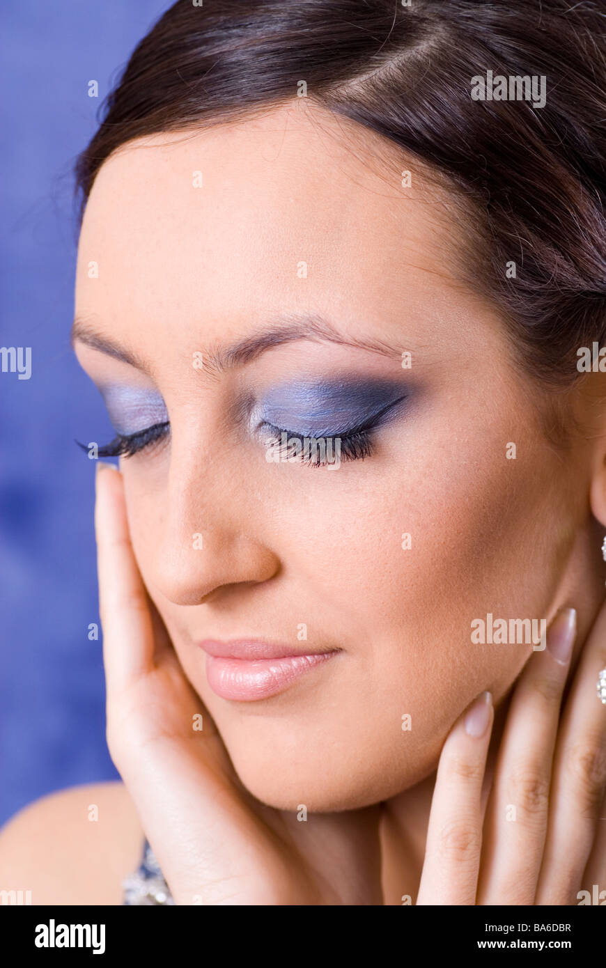 Beautiful young woman wearing blue eyeshadow eyes closed Stock Photo