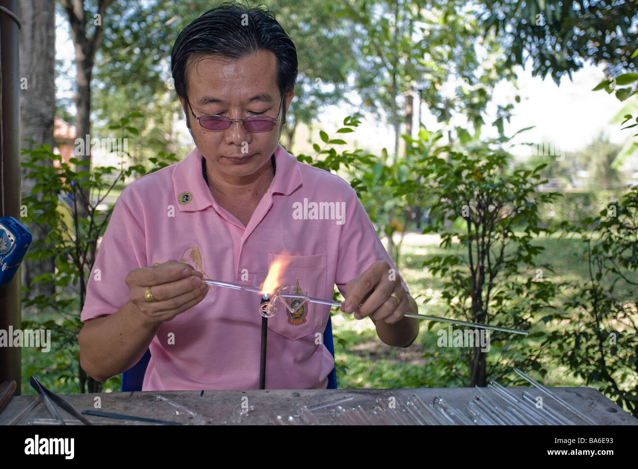 Craftsman glass sculpting at a Thai craft center creating tourist souvenirs. Pathum Thani Thailand S.E. Asia Stock Photo