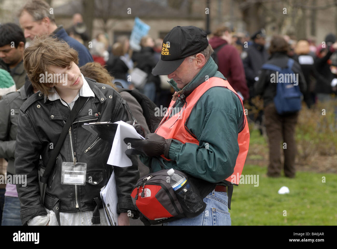 A teenage volunteer left collects signatures on a petition in Battery Park in New York Stock Photo