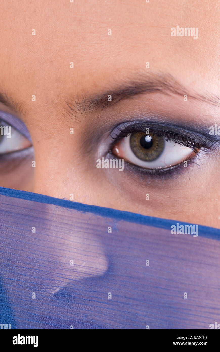 Young woman looking over a blue scarf Stock Photo