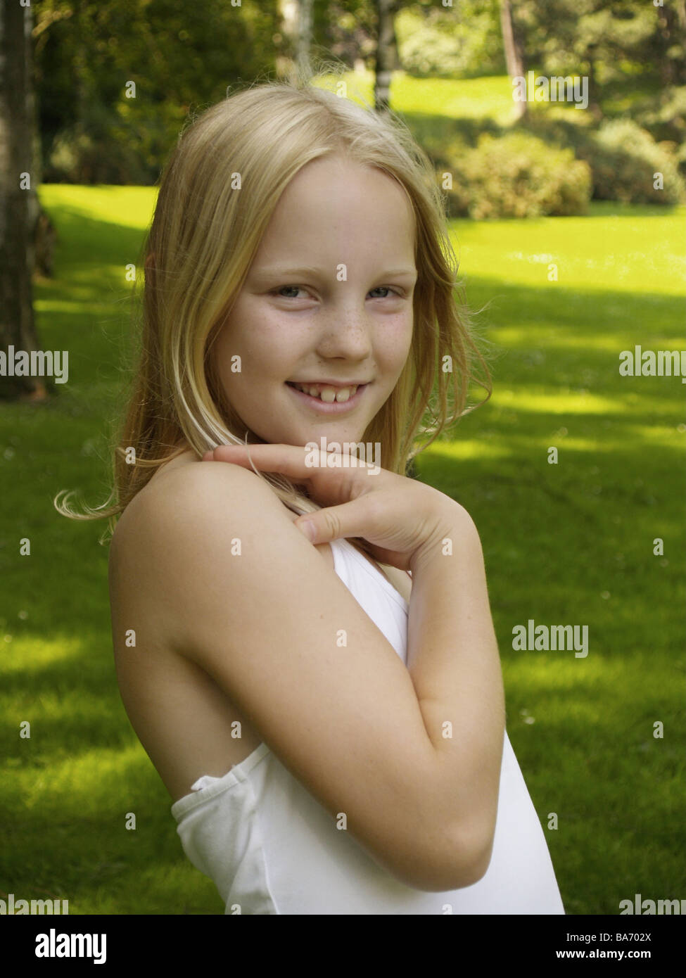 Girls blond smile pose semi-portrait at the side series people child-portrait child 9 years long-haired gaze camera happily top Stock Photo