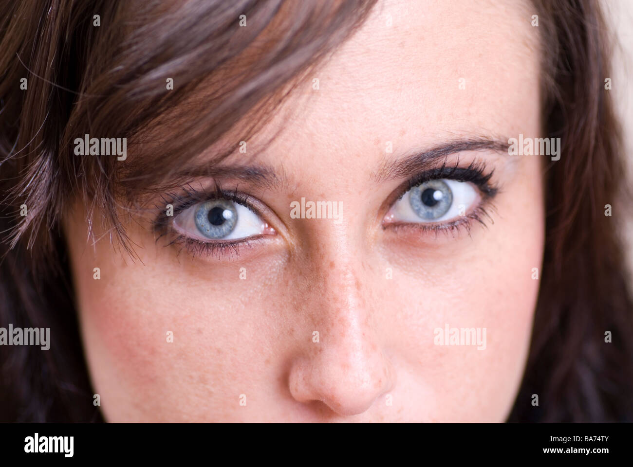 Close up of a young woman with blue eyes looking at camera Stock Photo