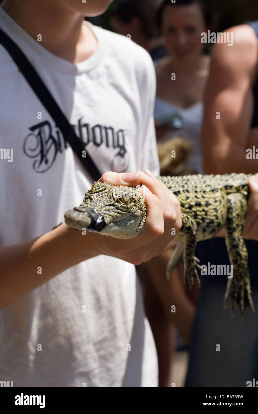Tourist holding a baby crocodile at Crocodylus wildlife Park.  Darwin, Northern Territory, AUSTRALIA Stock Photo