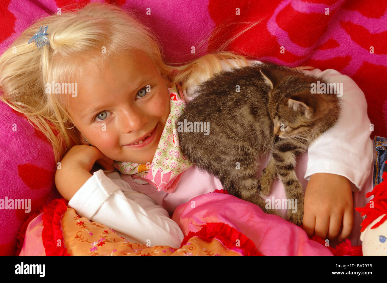 Girls smiles kittens cuddles lies portrait series people 5 years child-portrait child toddler blond gaze camera childhood Stock Photo