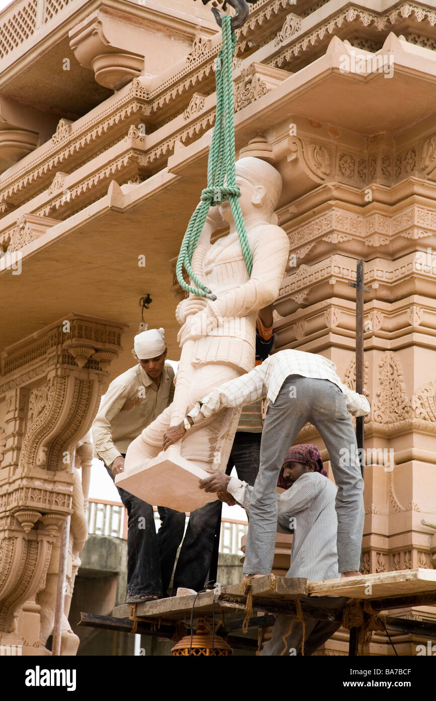 Builders hoist the statue of a Hindu Deity into place at the Baps Lord