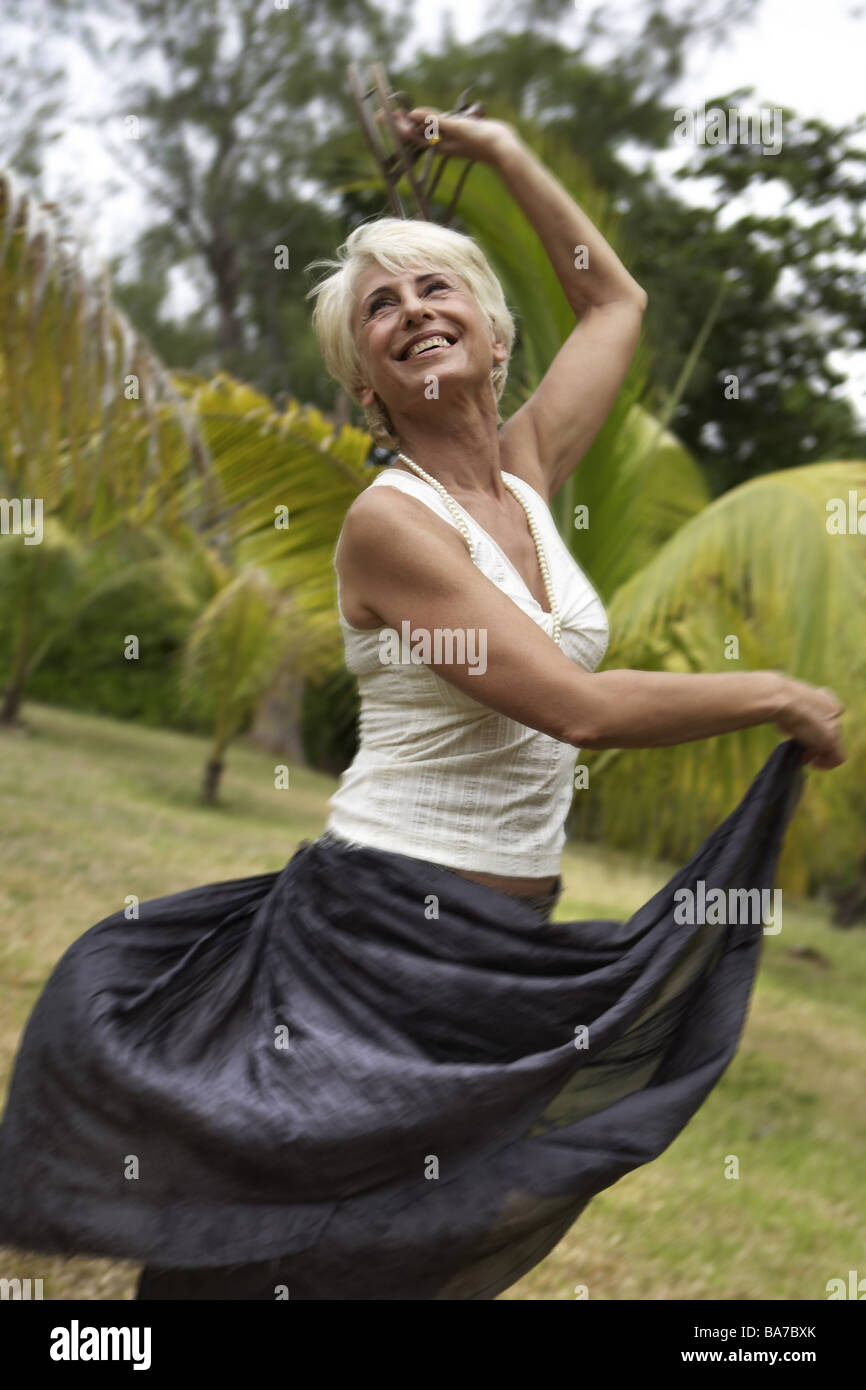 Palm-garden senior cheerfully omitted movement detail fuzziness series people 50-60 years 60-70 years seniors woman Top skirt Stock Photo