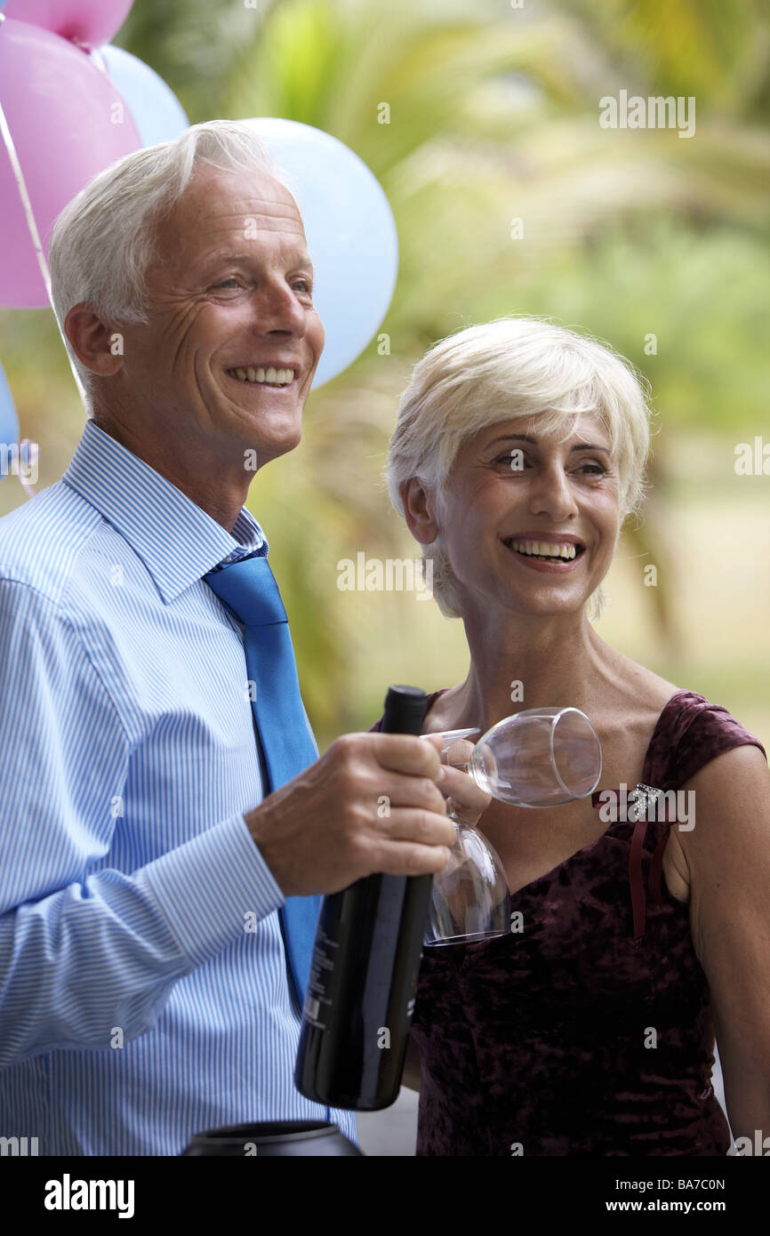Seniorpair wine bottle wine glasses holds cheerfully semiportrait