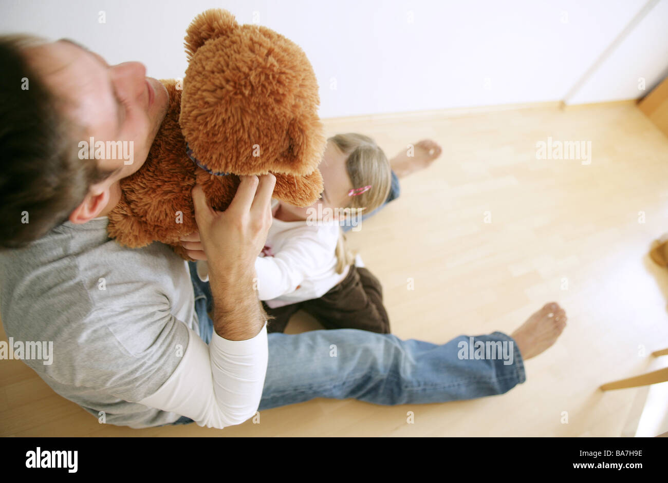 Father and daughter (3-4 years) playing with a teddy bear, Munich, Germany Stock Photo