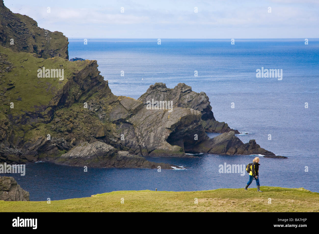 A woman walking along the coast of the Nature Protection Area, Hermaness, Island of Unst, Shetland islands, Scotland, Great Brit Stock Photo