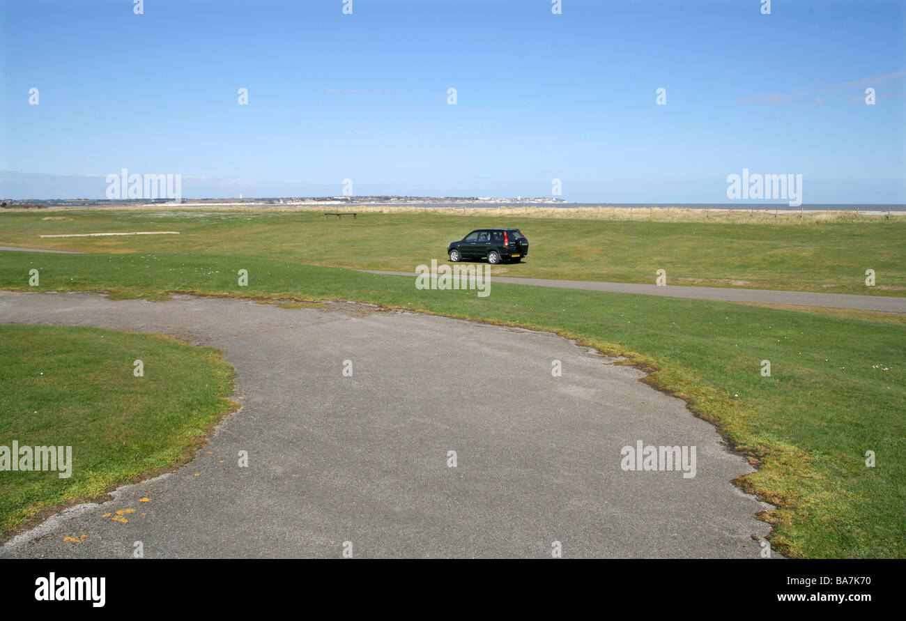 Single Black car on Grass verge at Sandwich Seafront Kent UK Stock Photo