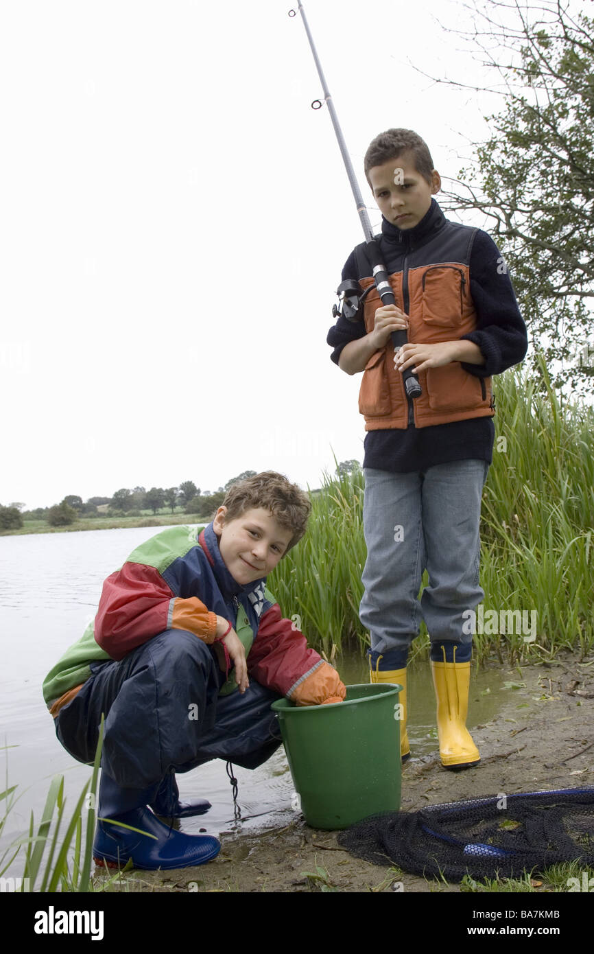Sea boys fishing rod-equipment buckets fish autumn series people children  two 11-13 years friends brothers rubber boots fishing Stock Photo - Alamy