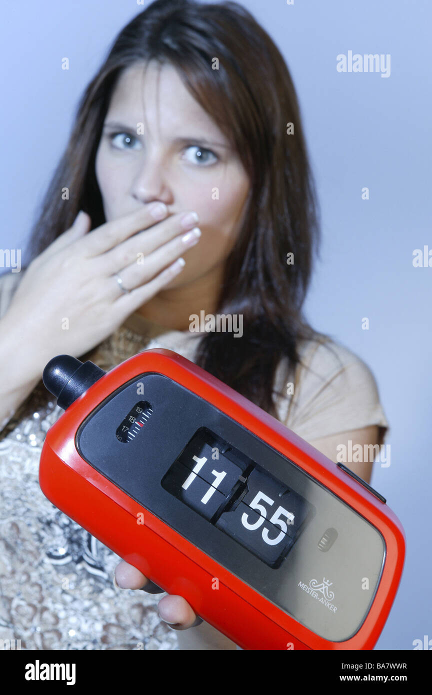 Woman young gesture startled alarm clocks five before twelve portrait