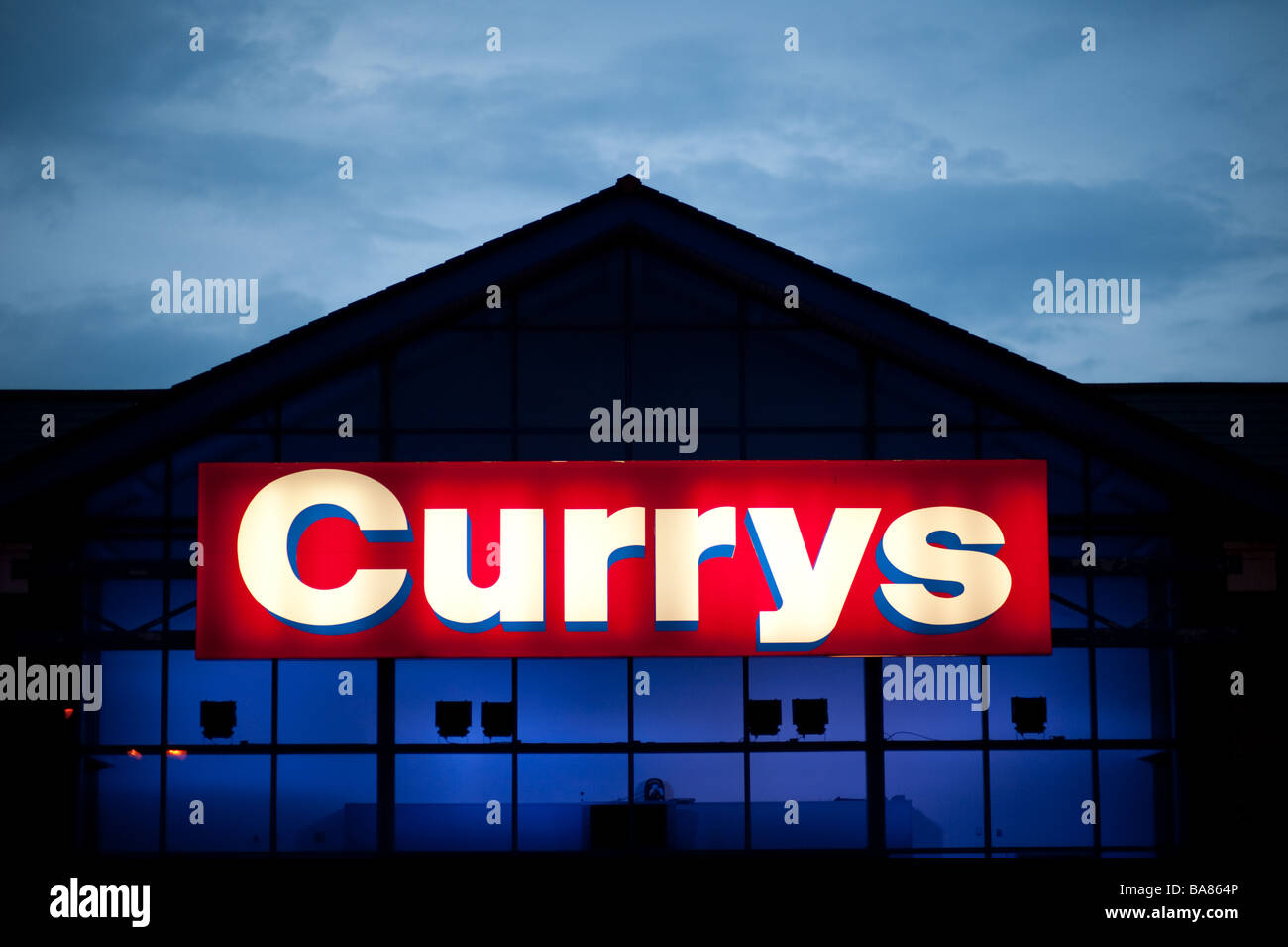 the illuminated sign at a Currys shop store exterior evening Stock
