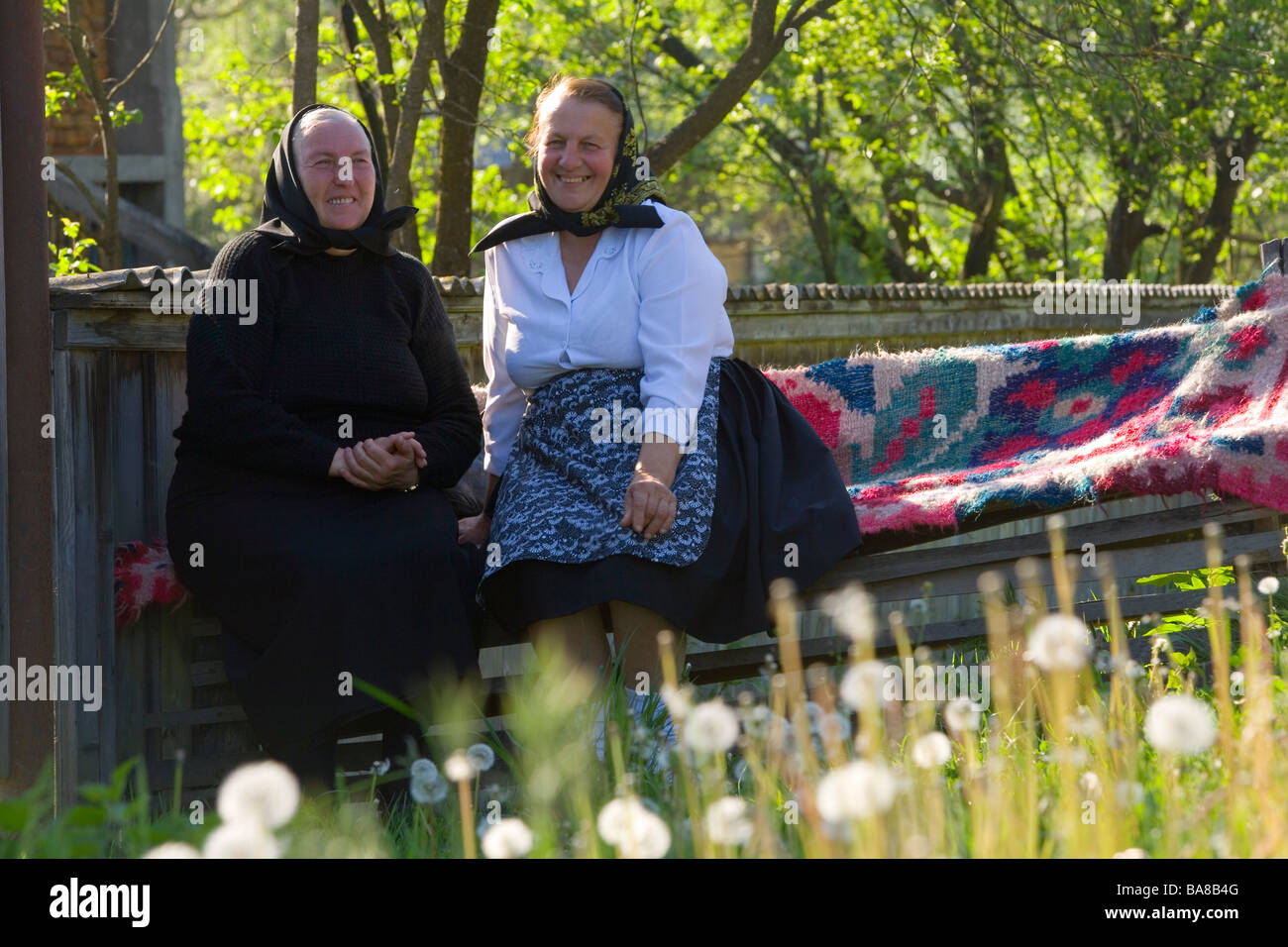 Elderly ladies chatting on bench, Maramures, Romania Stock Photo