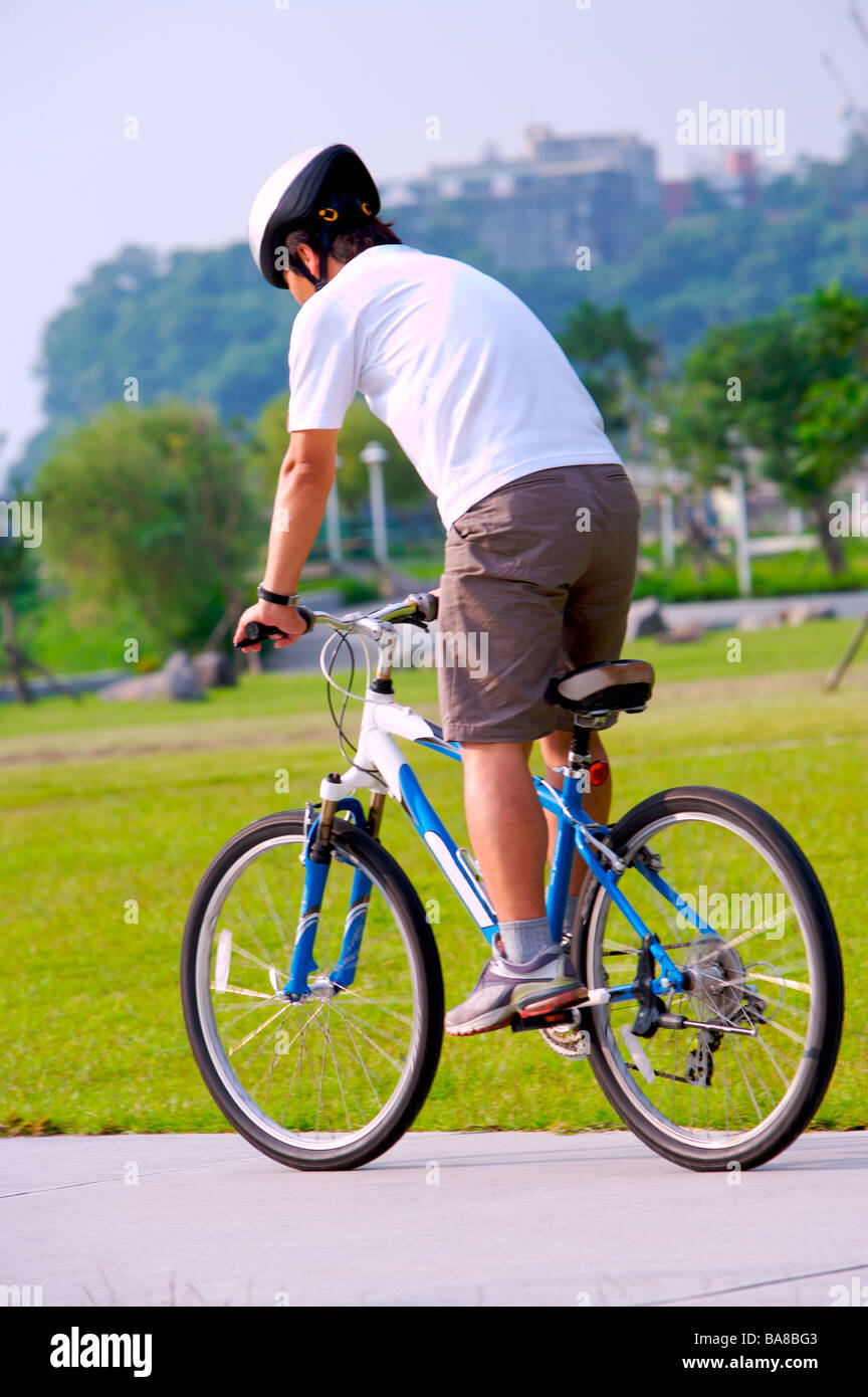 Man riding bicycle rear view Stock Photo - Alamy