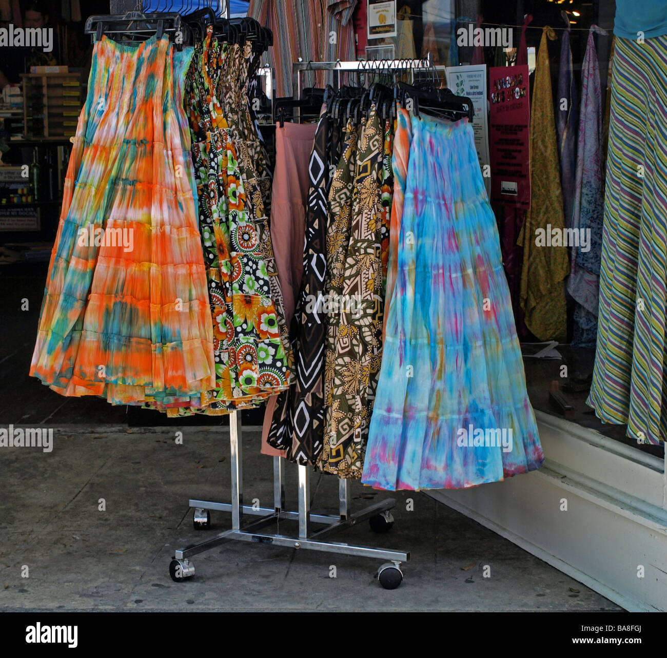 multi-colored dresses on a display rack outside of a store commercial establishment, skirts skirt Stock Photo